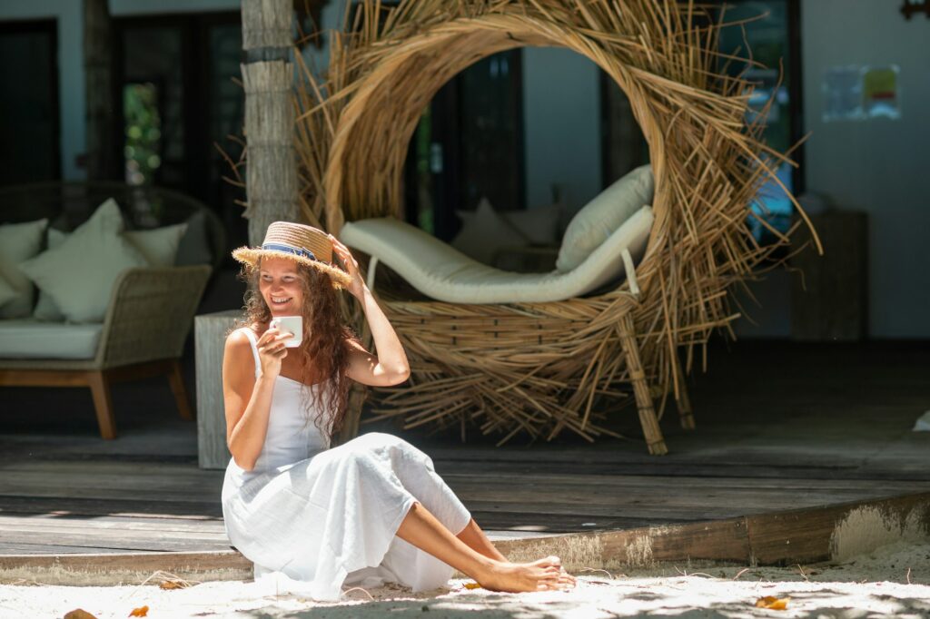 Happy smiling girl drinking coffee on the beach after massage. Wellness concept